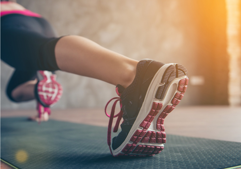 image femme qui fait un gainage avec gros plan sur sa basket de sport