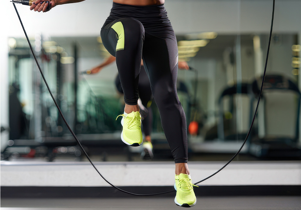 image femme qui fait de la corde a sauter avec des chaussure de sport en intérieur