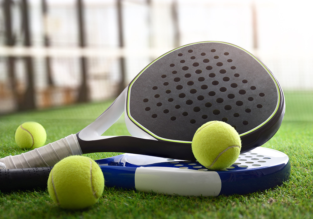 2 raquettes de padel avec des balles en gros plan sur un terrain de padel