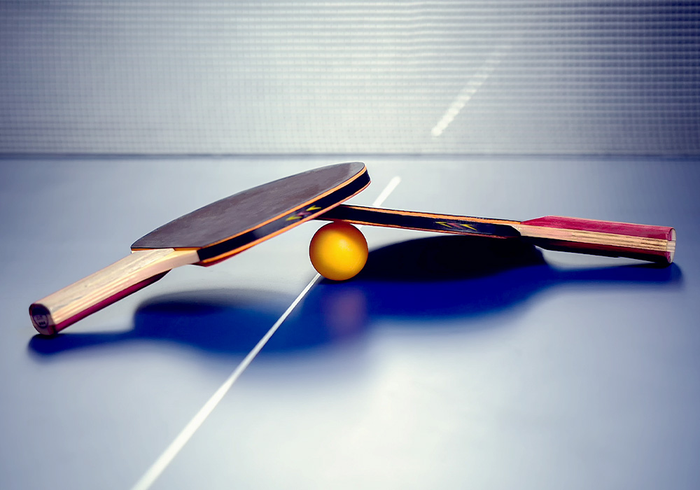 image 2 raquettes avec la balle sur une table de ping pong
