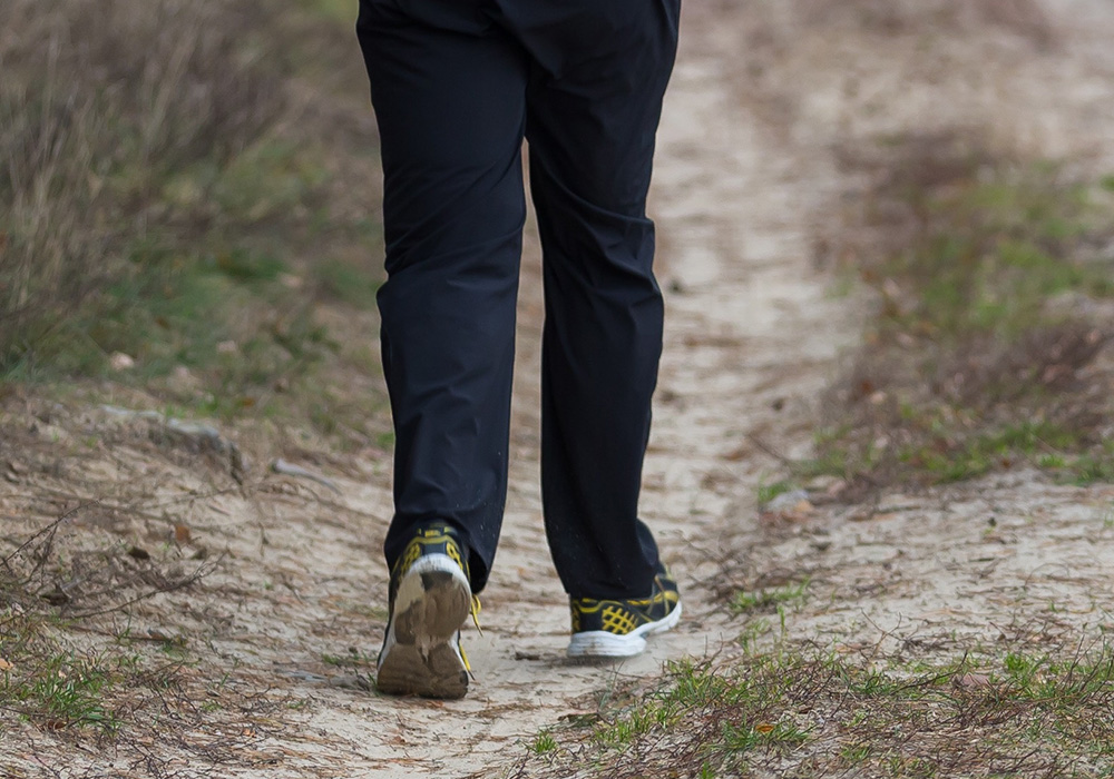 homme qui fait un trail sur un chemin avec un pantalon imperméable